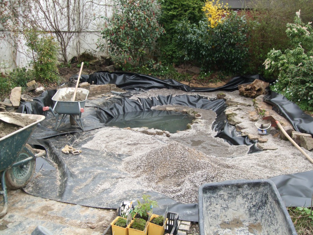 Einbringen der Folie . Im Hintergrund entsteht die Innenmodellierung und ein Wasserfall.